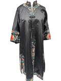 A black Chinese silk long robe or duster coat with colorful embroidered floral and scroll motifs around the collar, cuffs, and hem