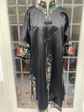 A black Chinese duster coat robe with colorful embroidered floral and scroll patterns around the collar, cuffs, and hem.